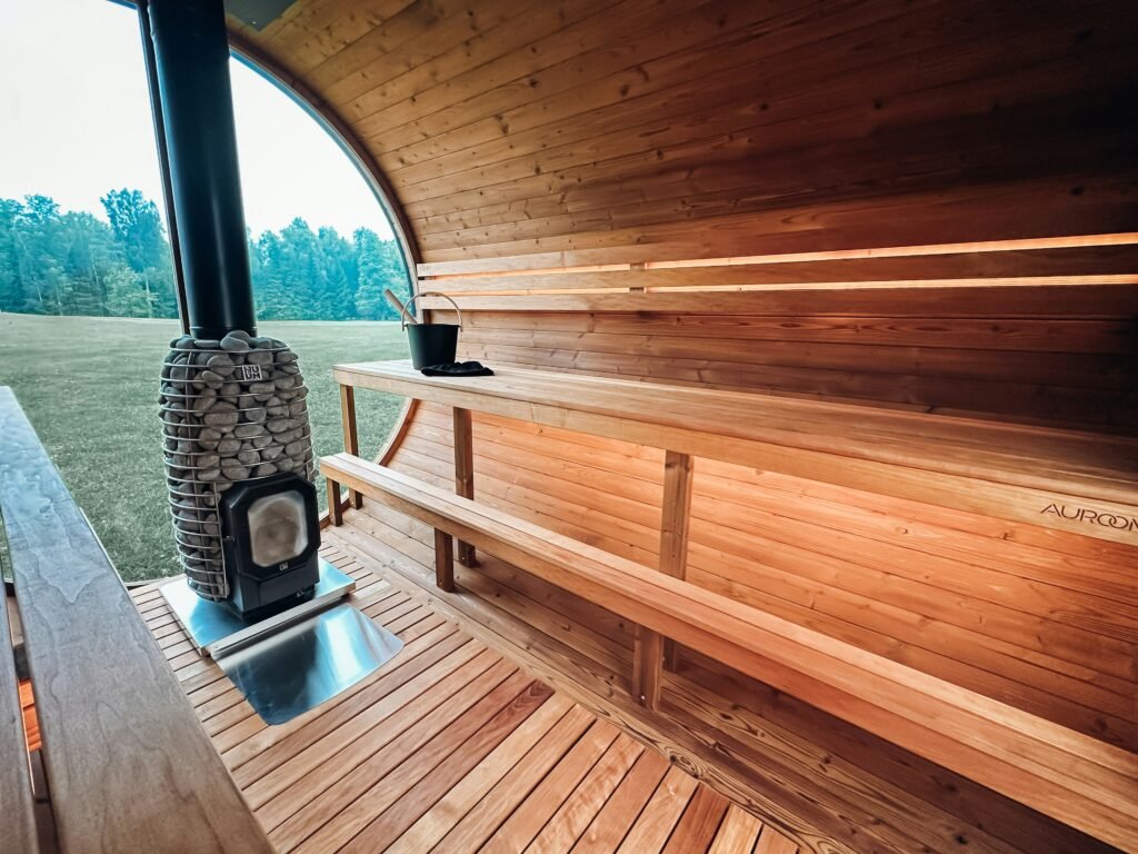 Interior of a wood fired wild sauna with wooden benches and a stone stove