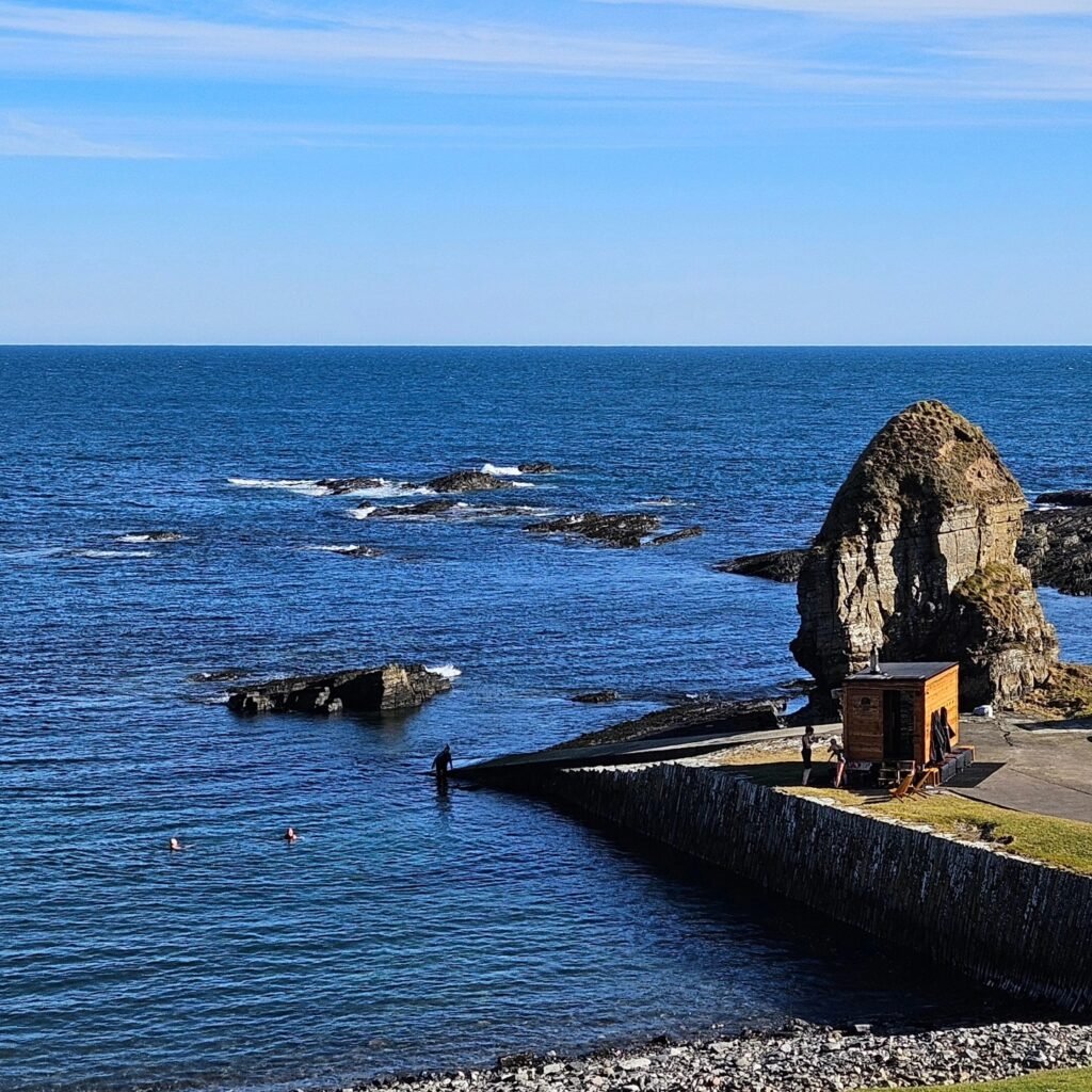 Mobile sauna set beside rocky harbour on Caithness coastline