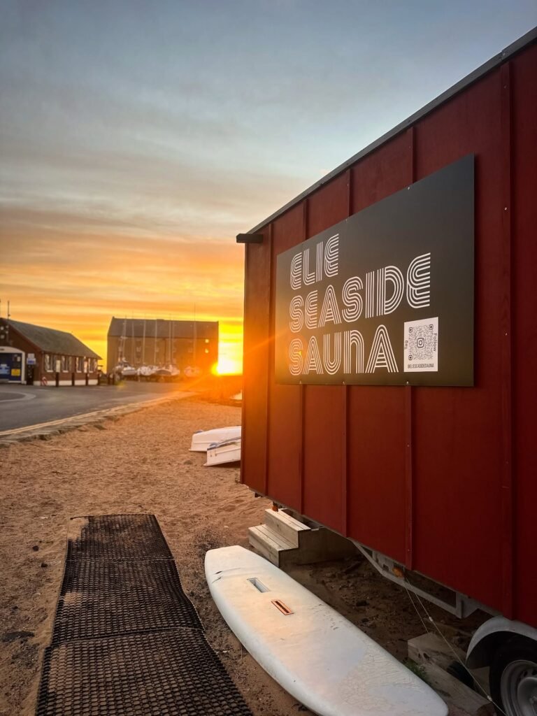 Elie Seaside Sauna sign on the beach at sunset in Fife, Scotland