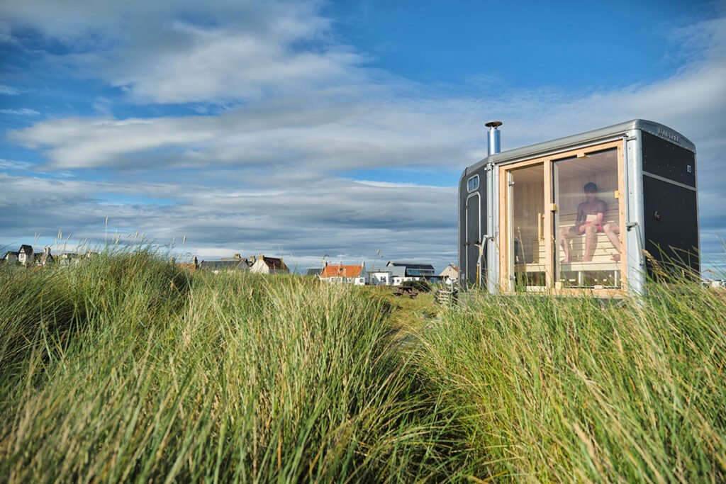 Elie Seaside Sauna set among coastal grass dunes near the beach in Fife, Scotland