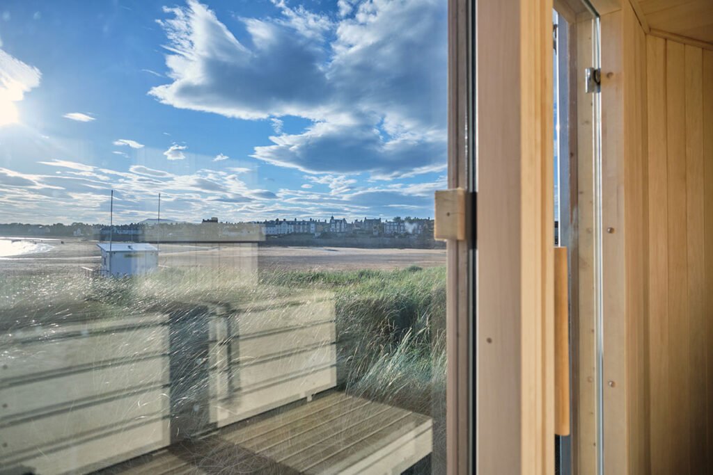 View from inside Elie Seaside Sauna looking out over the beach and coastline in Fife