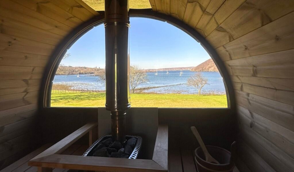View from inside the wood-fired sauna looking out over the water at Shieldaig Lodge