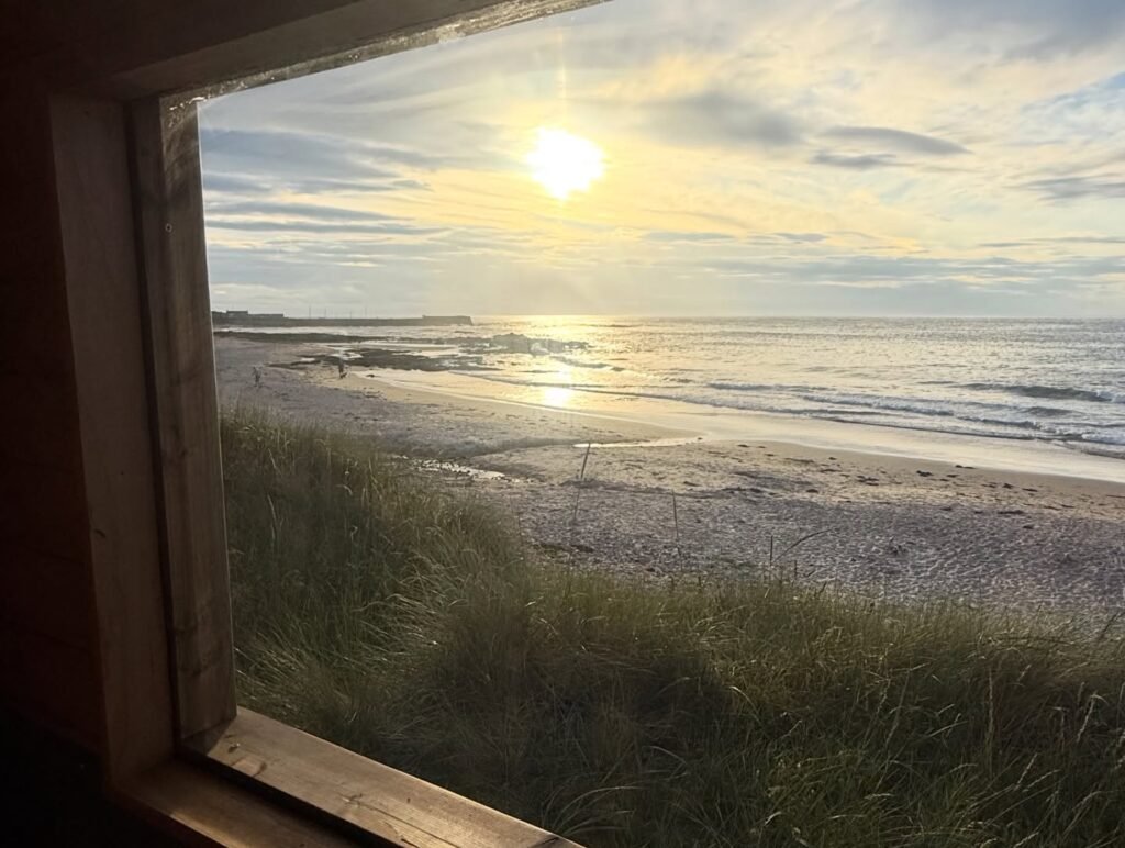 View from inside Fyrhus sauna looking out across the sea at Hopeman East Beach