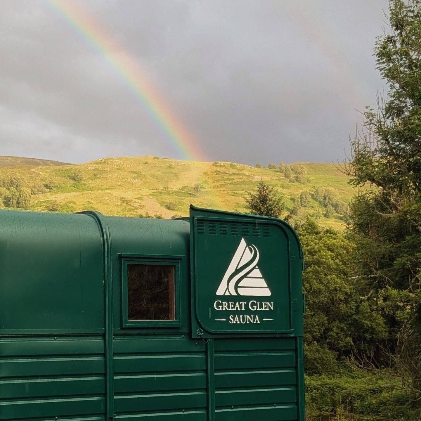 Outdoor sauna at Great Glen Sauna with a rainbow over the Scottish Highlands