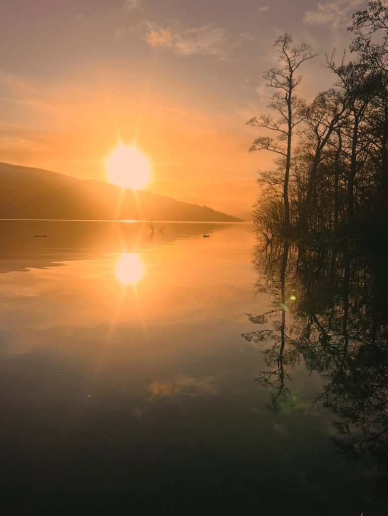 Sunrise over Loch Tay with calm water and reflections, setting of WildEmber Bothy sauna in Perthshire