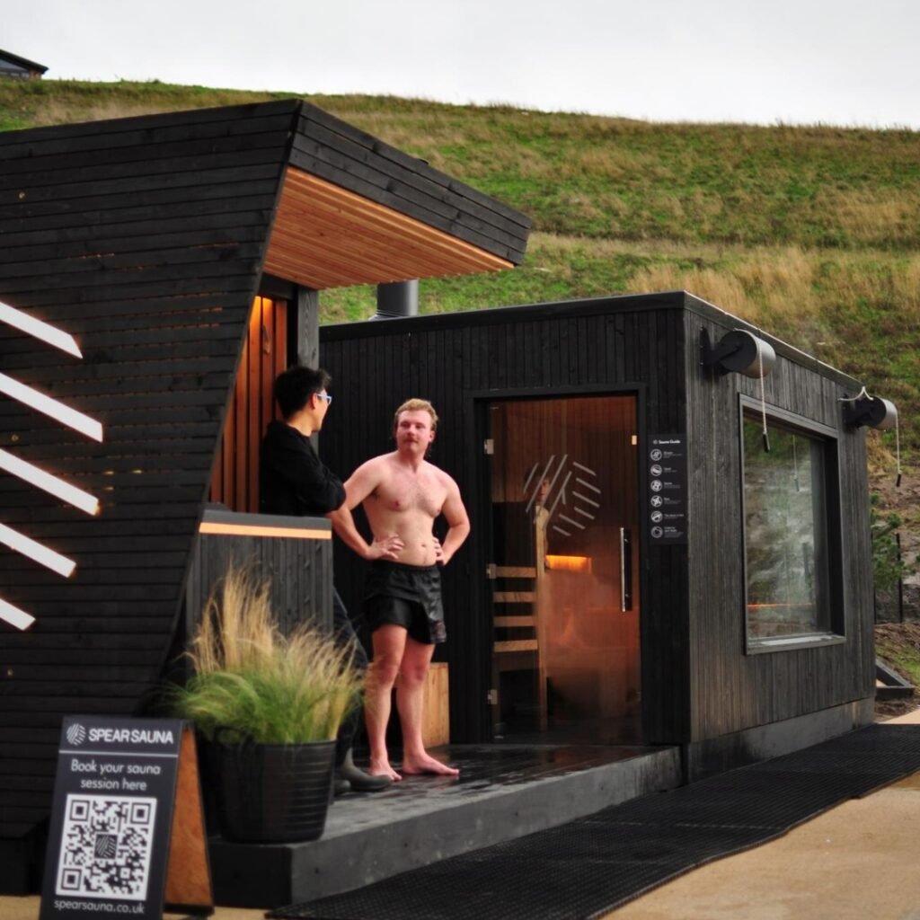 Exterior of Spear Sauna at Lost Shore Surf Resort in Edinburgh with people outside”