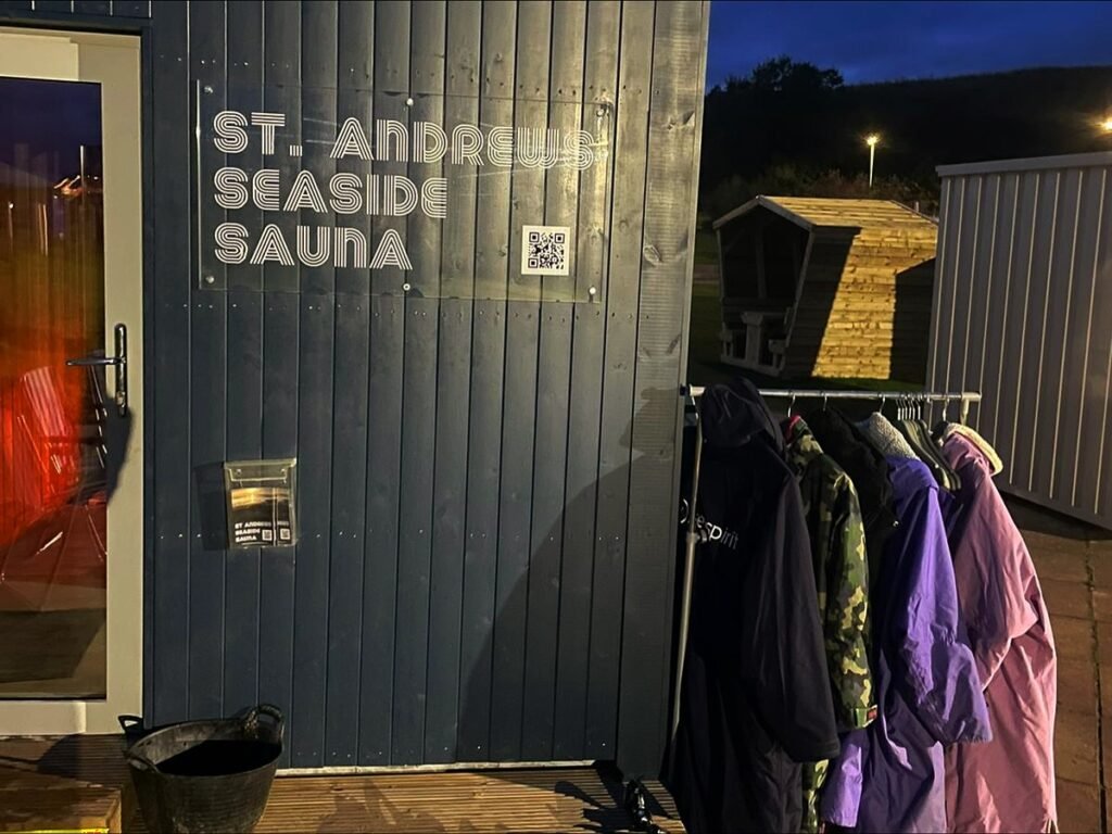 Exterior of St Andrews Seaside Sauna with entrance door and coats hanging outside