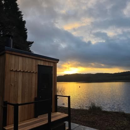 Wood-fired sauna beside Loch Ard at sunset at Sweat and Soak Sauna