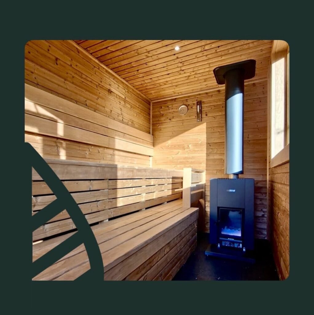 Interior of the wood-fired sauna at WildEmber Bothy in Perthshire with wooden benches and stove