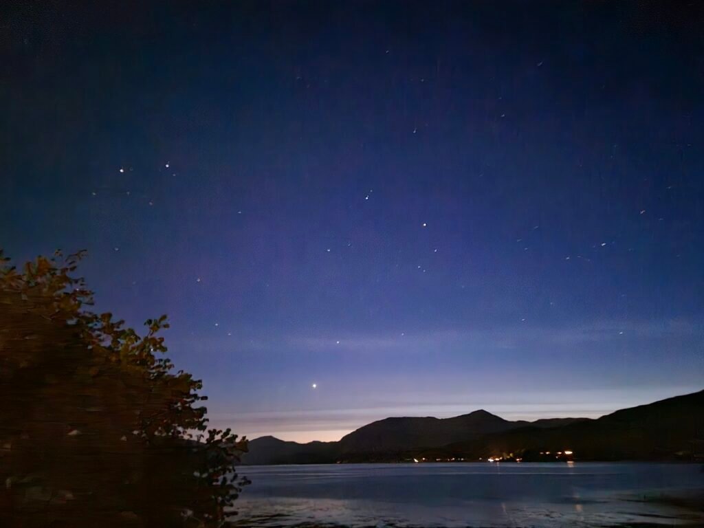 Night sky over Loch Linnhe with mountains in the distance