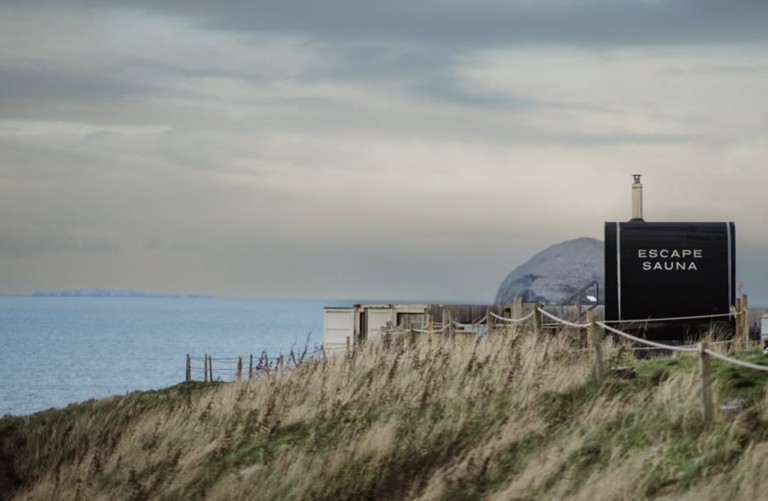 Escape Sauna North Berwick exterior at sunset with Bass Rock visible in the background