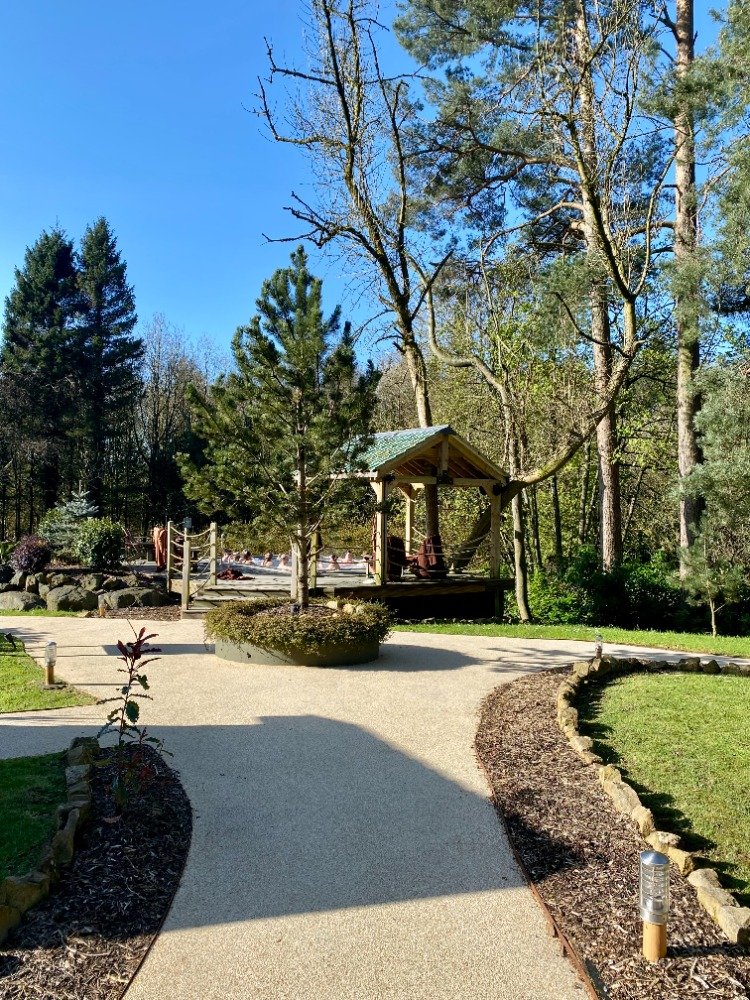 Woodland path leading to pergola lounge area at Galgorm Resort thermal spa village
