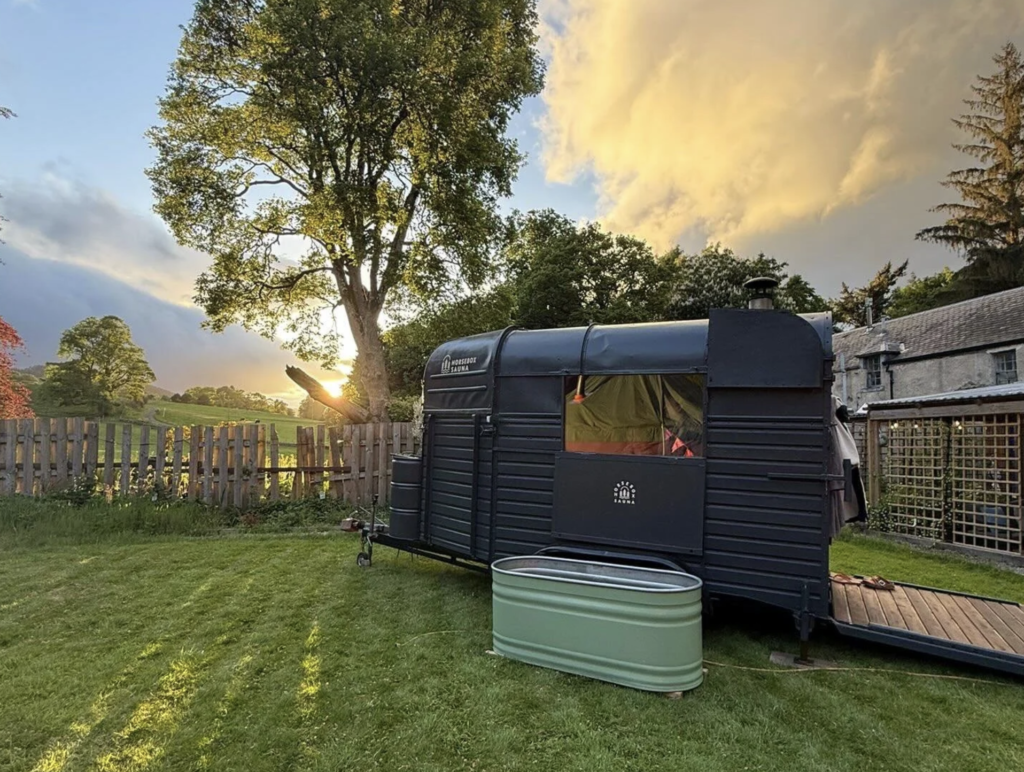 Horsebox Sauna Fife interior with wooden door open in a woodland garden setting