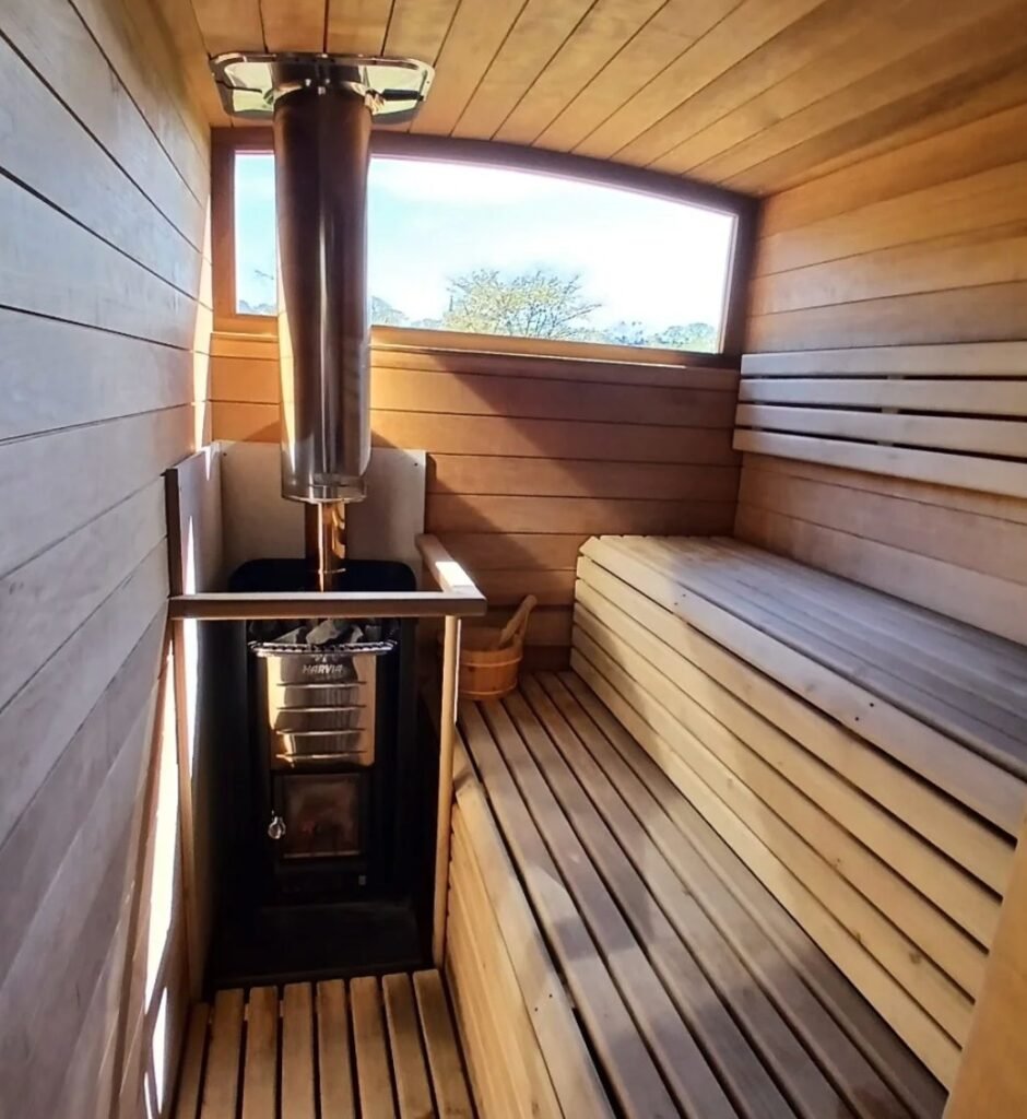 Inside Puffin Sauna Leith showing the wood-fired Harvia stove and wooden benches