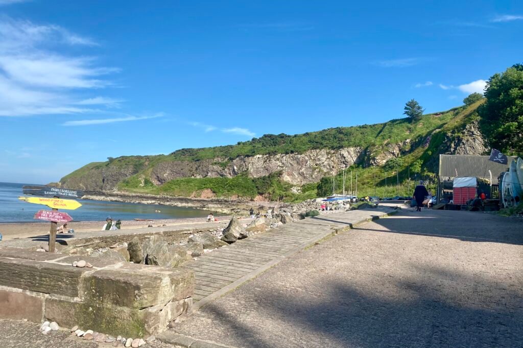 Stonehaven harbour and beach on a sunny evening, busy with locals and visitors