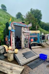 Driftwood Sauna Stonehave and changing area at Stonehaven Harbour, both decorated with reclaimed nets, buoys and driftwood