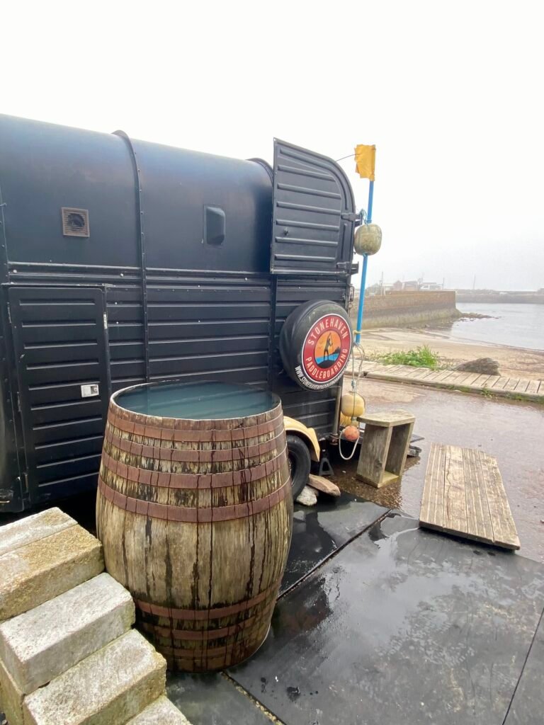 Whisky barrel cold plunge outside Driftwood Sauna, looking out to sea at Stonehaven Harbour