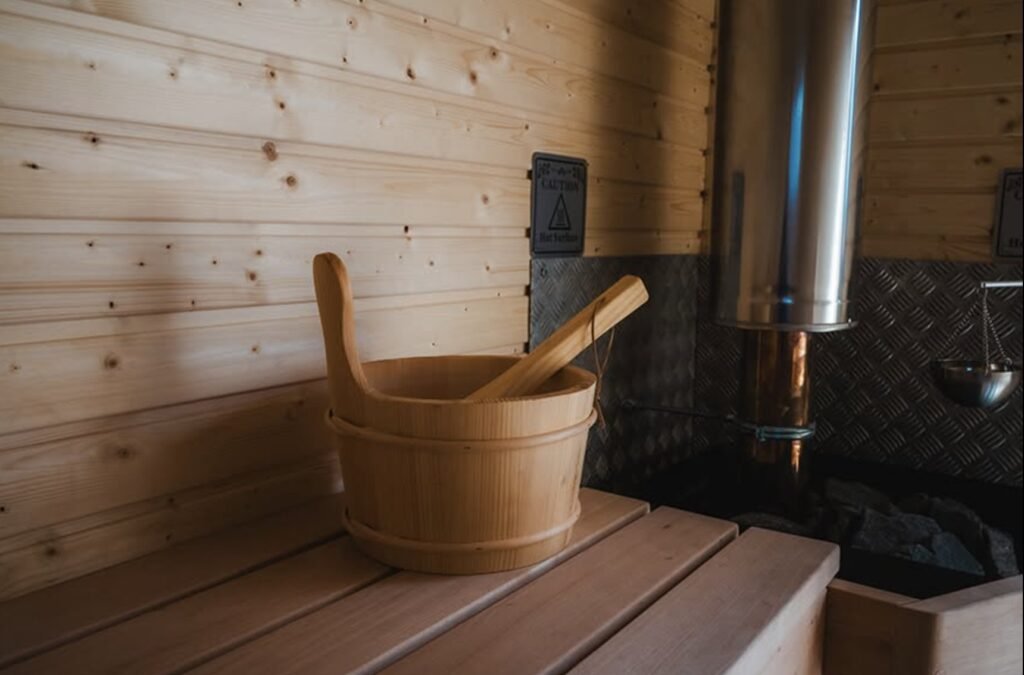 Fraileach Sauna Cruden Bay interior detail, wooden bucket and ladle beside the stove flue