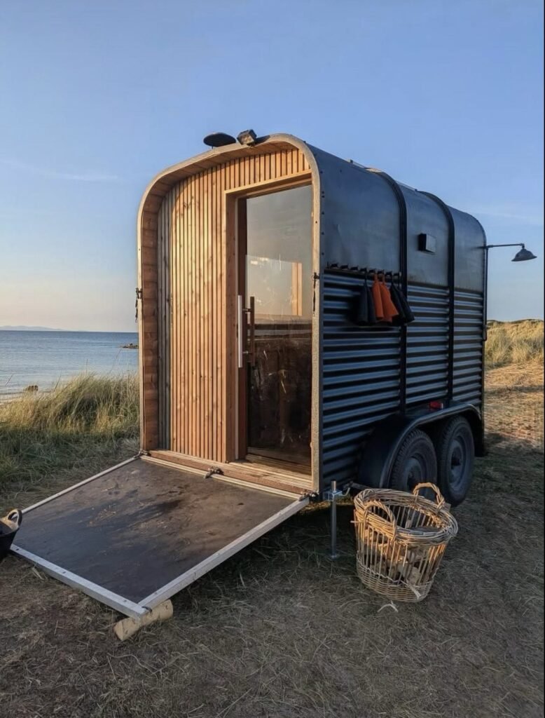 Fyrhus Sauna Hopeman exterior at golden hour with the door open to the sea