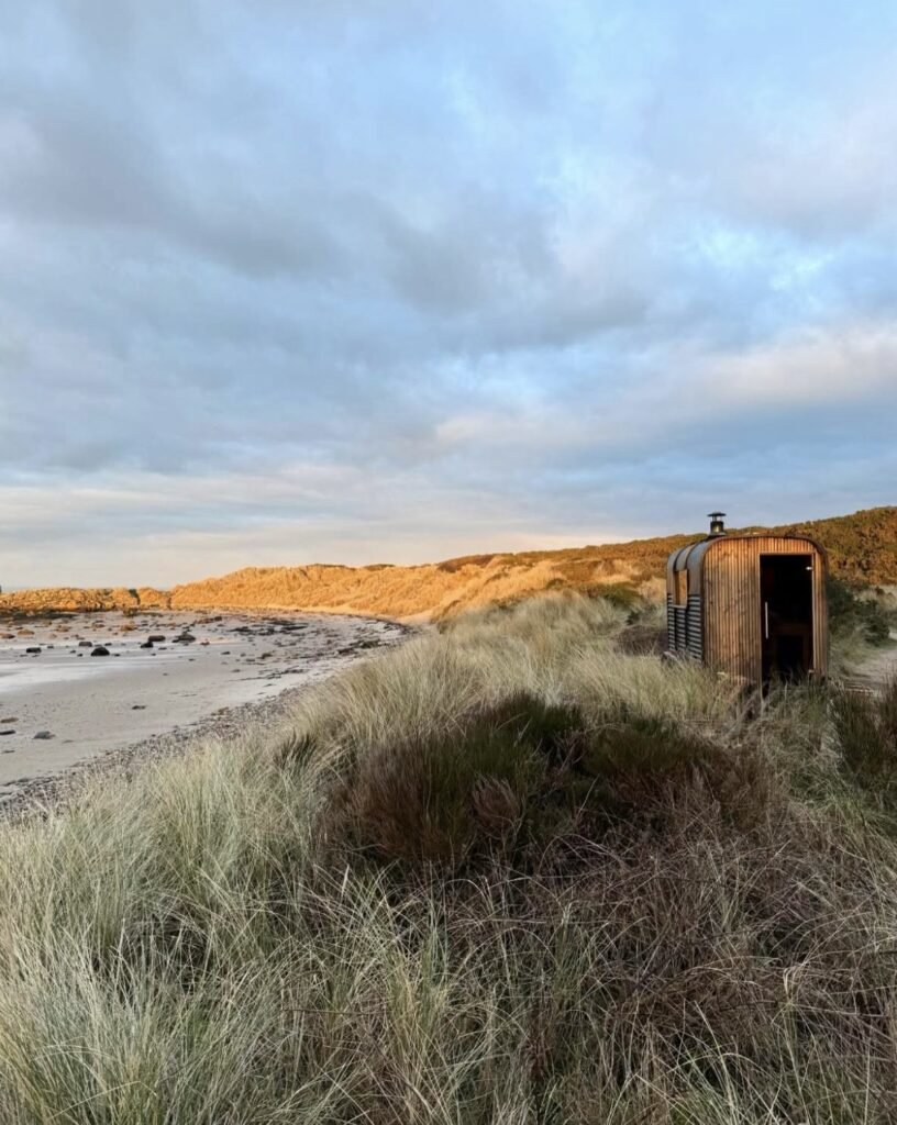 Fyrhus Sauna Hopeman on the dunes at golden hour overlooking the beach