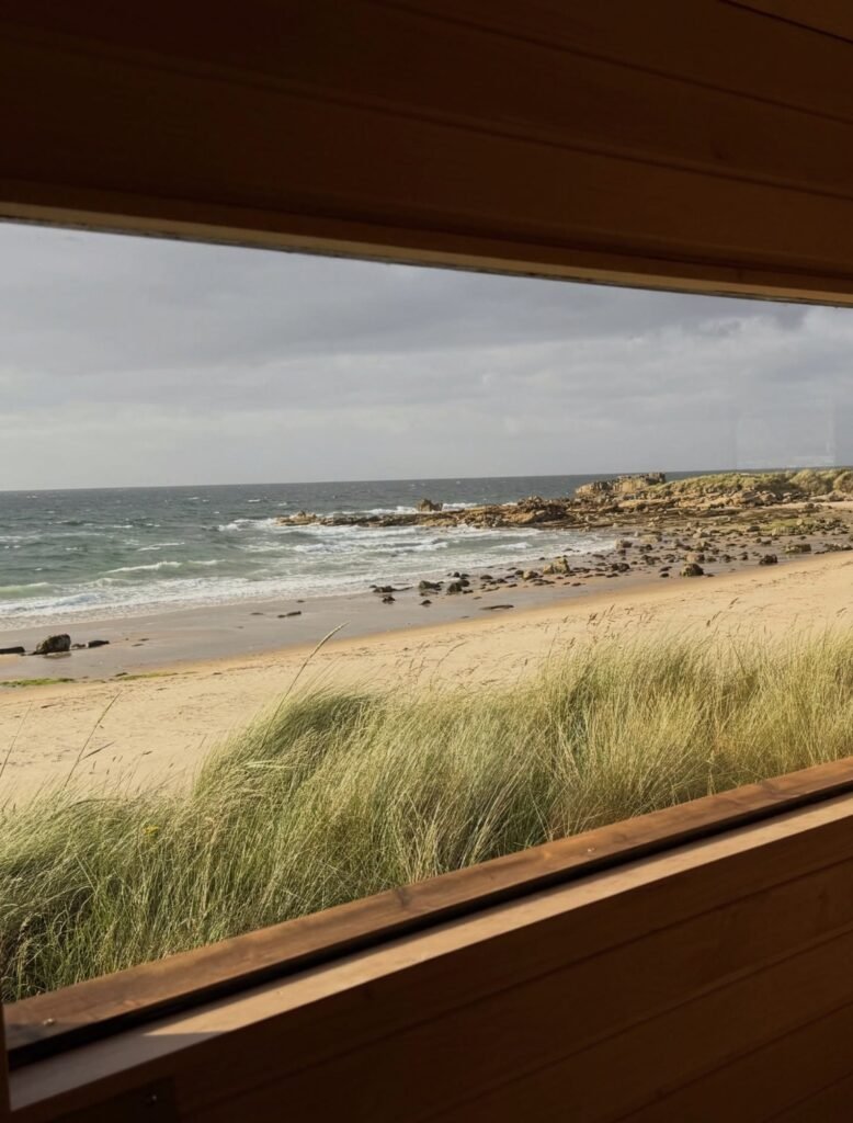 Fyrhus Sauna Hopeman sea view from inside looking out over the rocks and beach