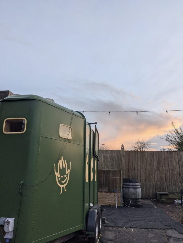 Glasgow Community Sauna Pollokshields horsebox exterior at sunset with string lights