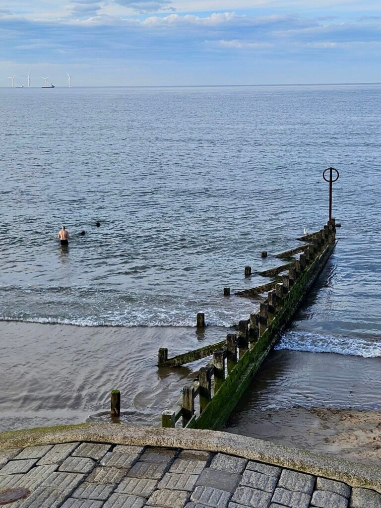 Man wading into sea at promenade in Aberdeen