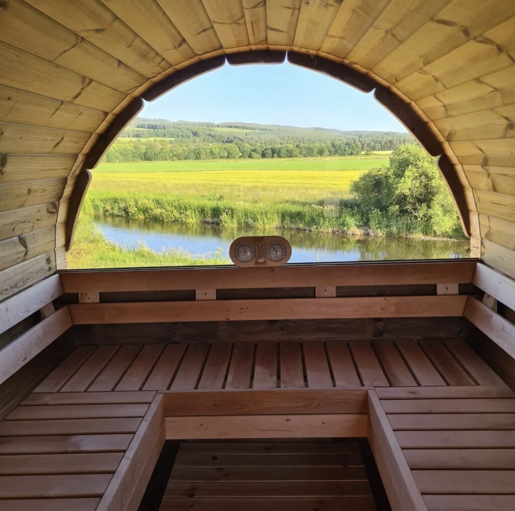 The Little Sauna Keig interior looking out to the sheep field through the arched window