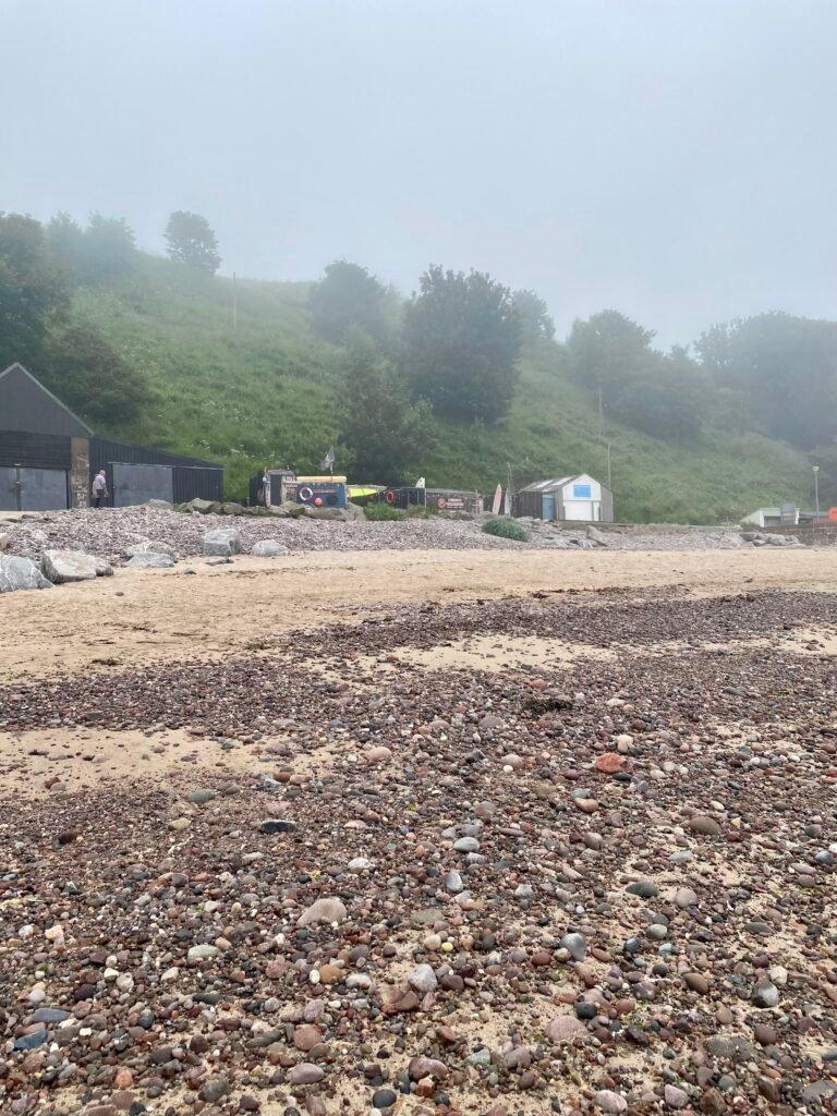 Looking up from the pebble and sand beach towards Driftwood Sauna, Stonehaven