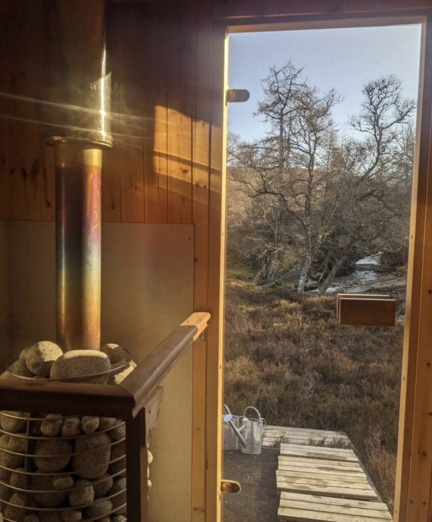 Wild Braemar Wilderness Sauna Cairngorms interior looking out to the river at golden hour