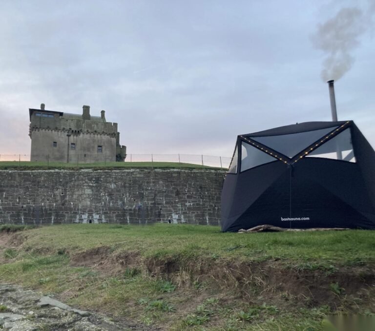 Bees Sauna Broughty Ferry Castle at dusk with smoke rising from the chimney