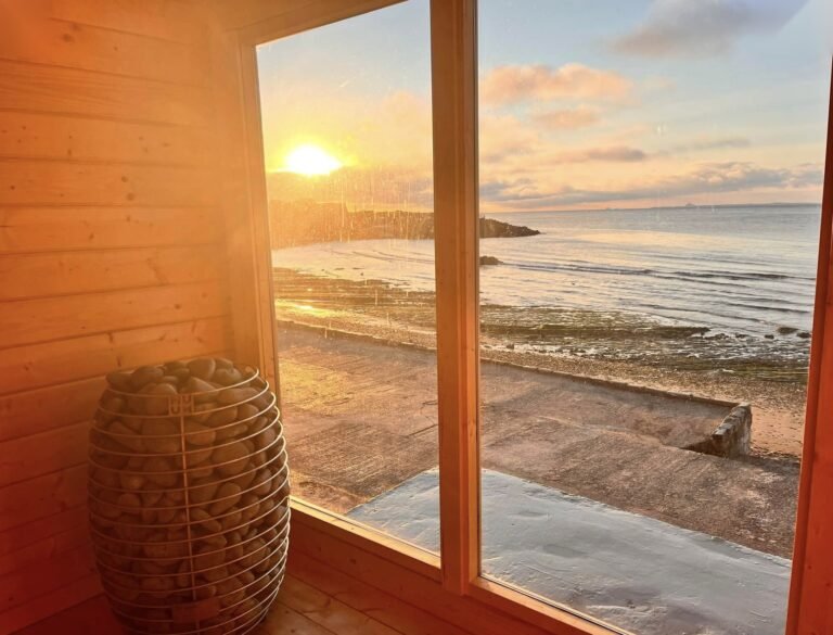 Soul Kist Sauna Kinghorn interior with stove and sunset view over the beach