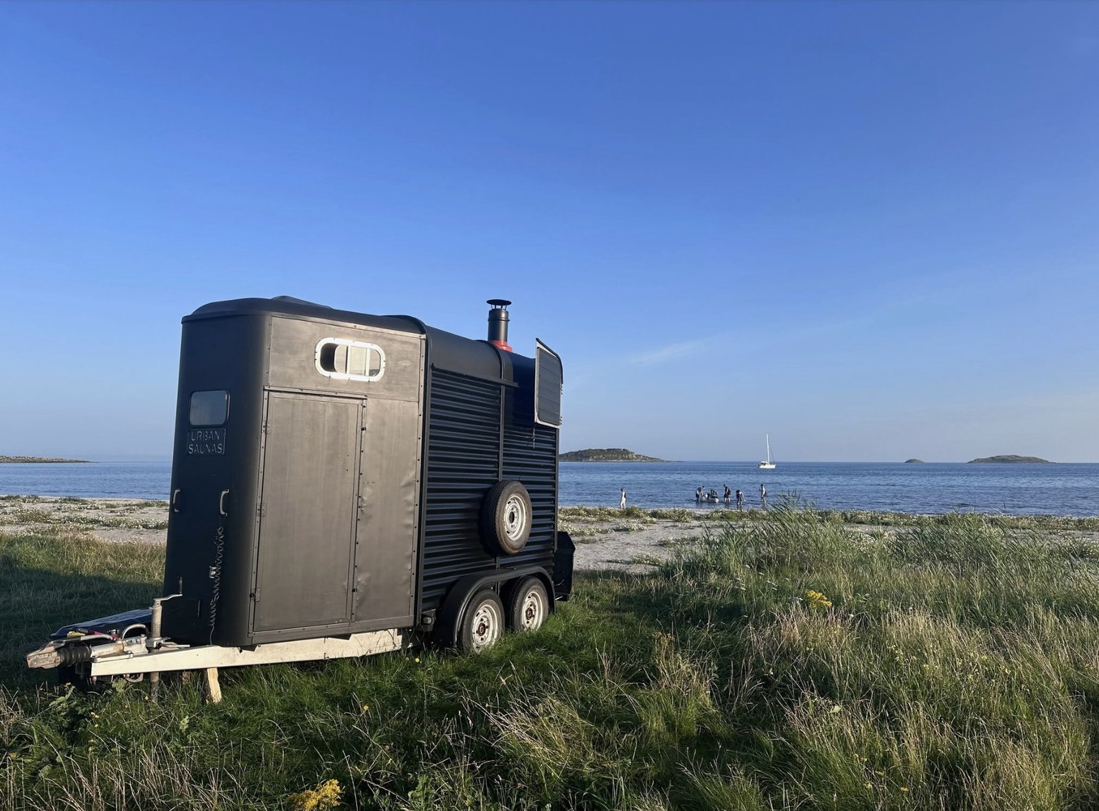 Bothan Jura Wild Sauna Isle of Jura converted horsebox sauna on the grass beside the shore with the sea behind