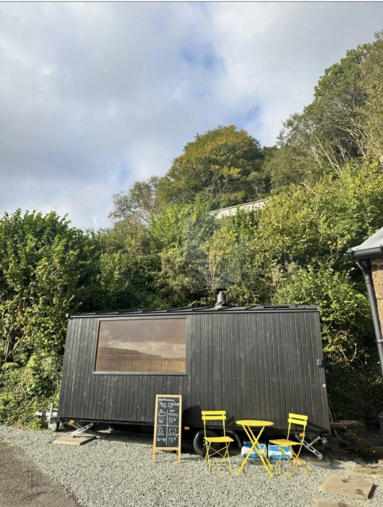 Portree Sauna Isle of Skye exterior with bistro chairs and chalkboard sign
